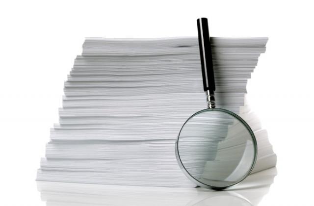 Magnifying glass and stack of papers